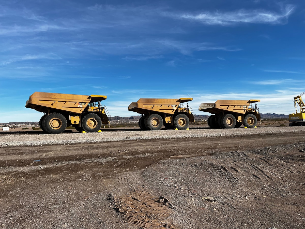 Fleet of dump trucks on road — heavy construction vehicles